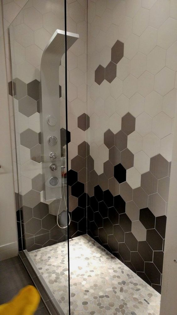 Azulejos geométricos hexagonales en diferentes tonos en la ducha