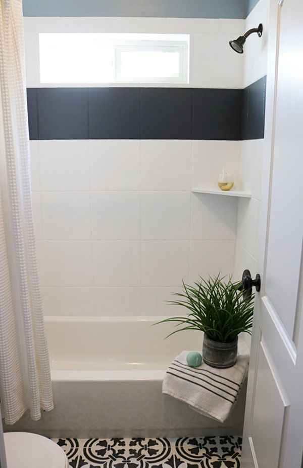 Un cuarto de baño con los azulejos pintados en dos colores blanco y negro