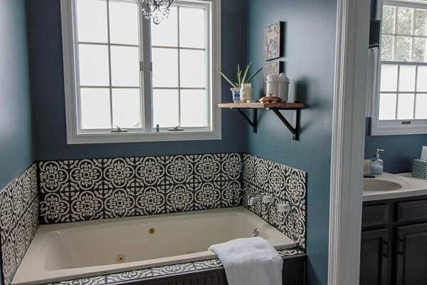 Un cuarto de baño con los azulejos pintados en dos colores, blanco y negro