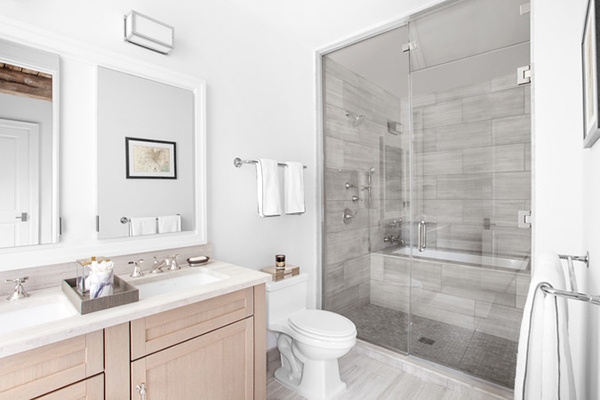 Un baño en tonos grises, blancos y con muebles de madera natural