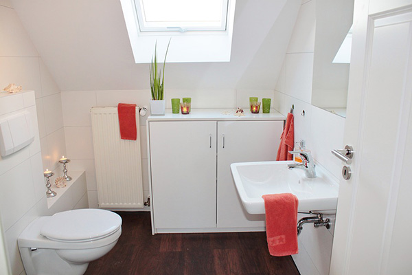 Un cuarto de baño pequeño en blanco con detalles rojos y verdes