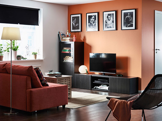 Un salón con paredes naranjas combinado con muebles negros