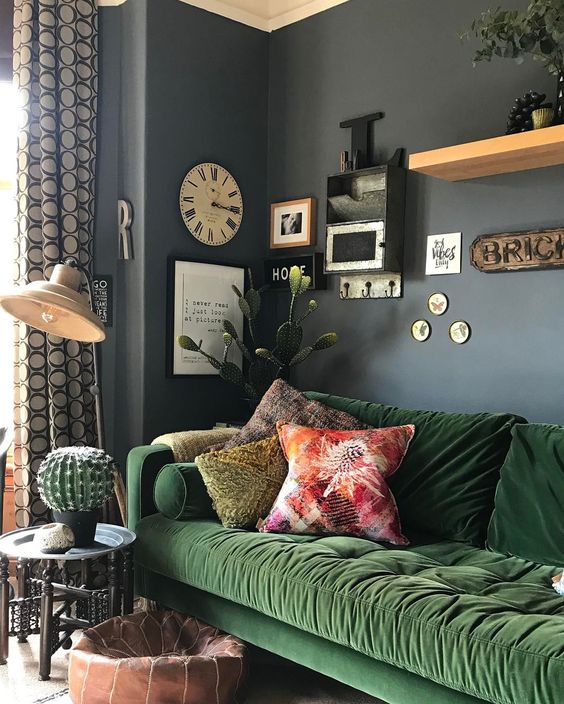 Un salón que combina azul marino en paredes y verde en sofá