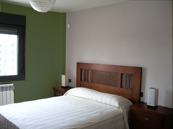 Un dormitorio que combina gris piedra y verde oscuro. Colores que combinan con el color piedra.