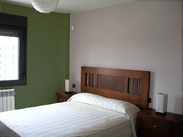 Un dormitorio que combina gris piedra y verde oscuro. Colores que combinan con el color piedra.