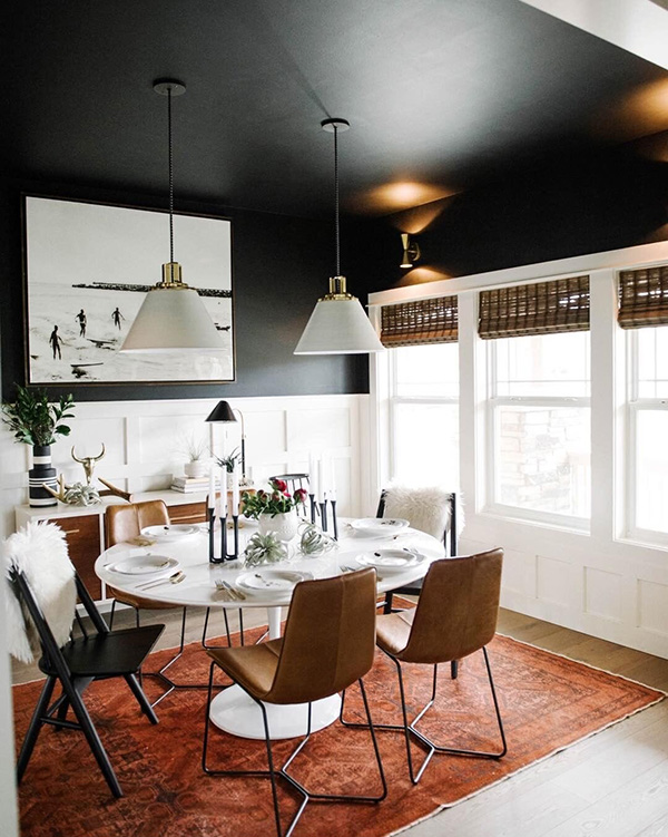 Un comedor que combina color negro en paredes y techo y marrón en muebles
