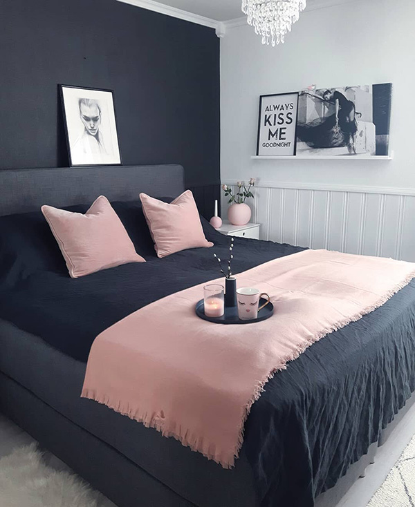 Un dormitorio que combina en paredes color negro y rosa en textiles
