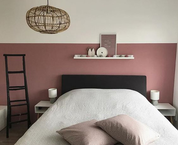Un dormitorio matrimonial con un zócalo rosa oscuro