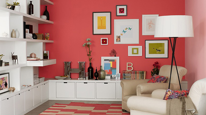 Un salón que combina color coral en paredes con blanco en los muebles