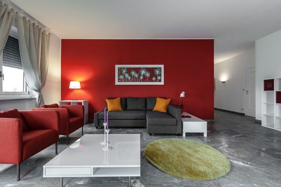 Color rojo en pared combinado con sofá gris