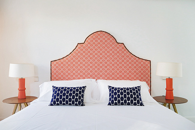 Un elegante dormitorio con el cabecero tapizado en tonos coral