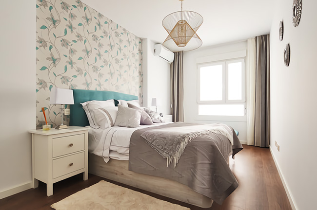 Un encantador y moderno dormitorio decorado en tonos neutros con papel pintado en el cabecero