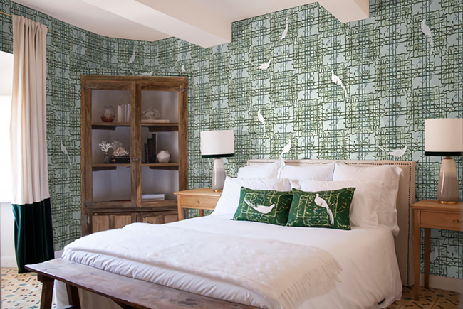 Un dormitorio decorado con papel pintado en tonos verdes