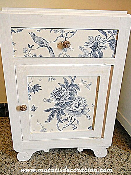 Un mueble decorado con papel pintado y pintura.