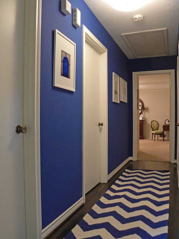 Un pasillo estrecho decorado y pintado en azul y blanco