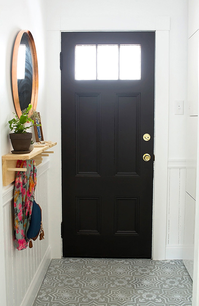 Un recibidor pequeño con la puerta pintada de negro