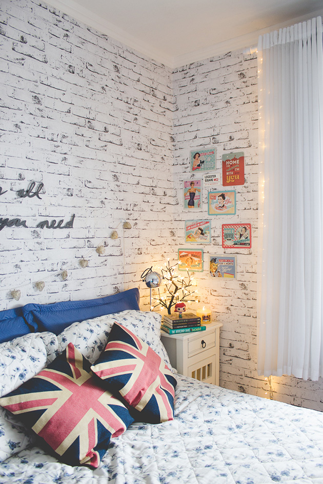 Un dormitorio con las paredes de imitación a ladrillo visto pintado de blanco desgastado