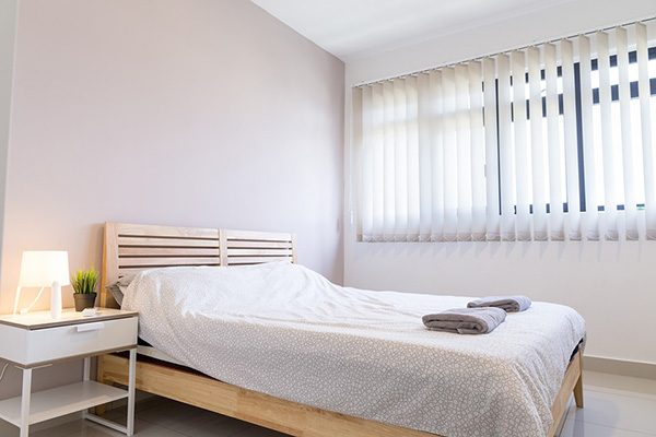 Un dormitorio con muebles de madera clara pintado de lila