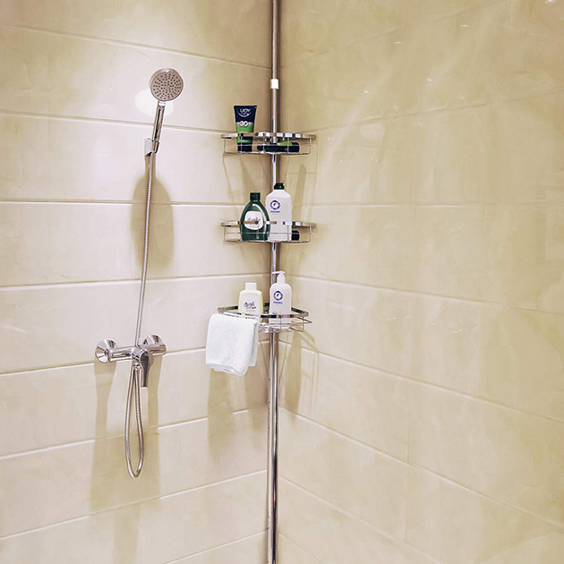 Soluciones de almacenamiento para baños pequeños, una barra extensible para la ducha con estantes rinconeros.
