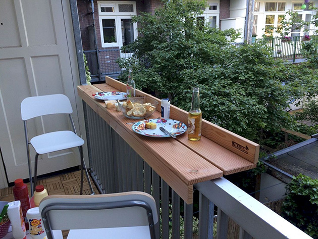 Una terraza pequeña con una barra en la barandilla