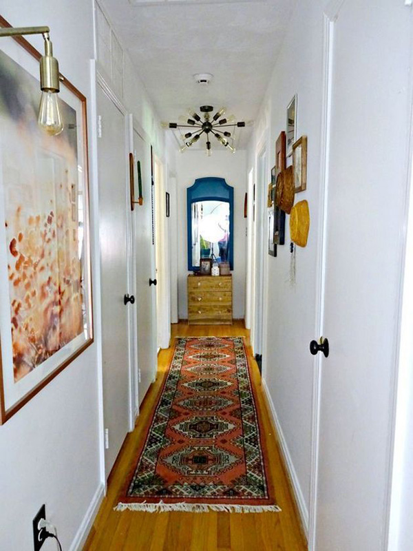 Un pasillo estrecho decorado con cuadros en las paredes