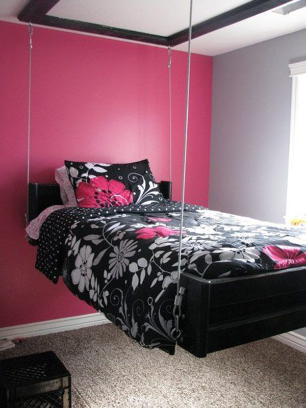 Un dormitorio, cuarto o habitación moderna pintada y decorada en rosa y gris con la cama suspendida