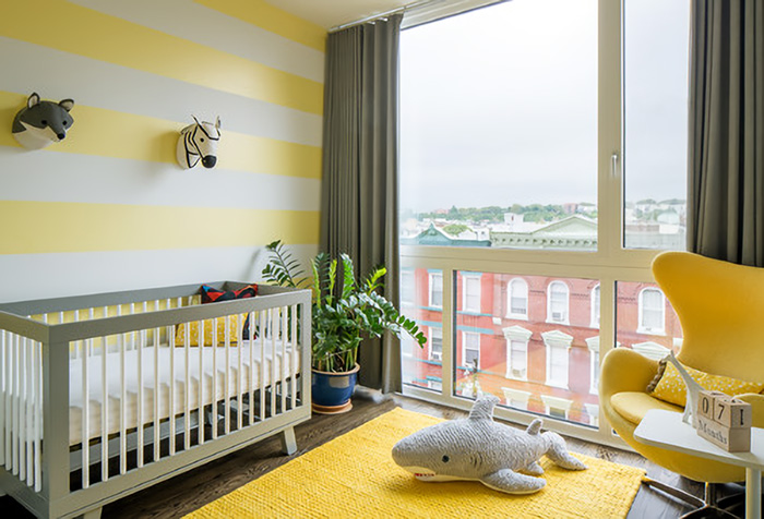 Una habitación con cortinas grises y paredes amarillas