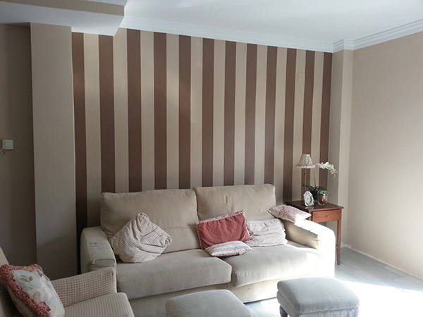 Un salón pintado y decorado a rayas verticales en tonos marrones