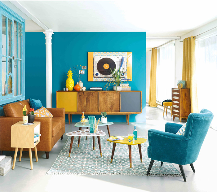 Un salón de Maisons du Monde turquesa con muebles marrones