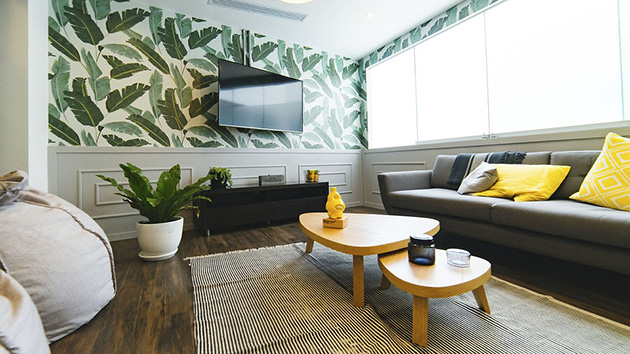 Un salón pequeño con papel pintado tropical