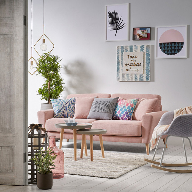 Un salón con un sofá rosa