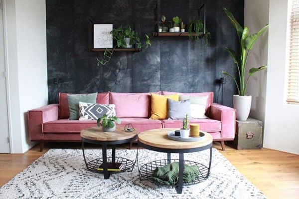 Un salón con un sofá rosa